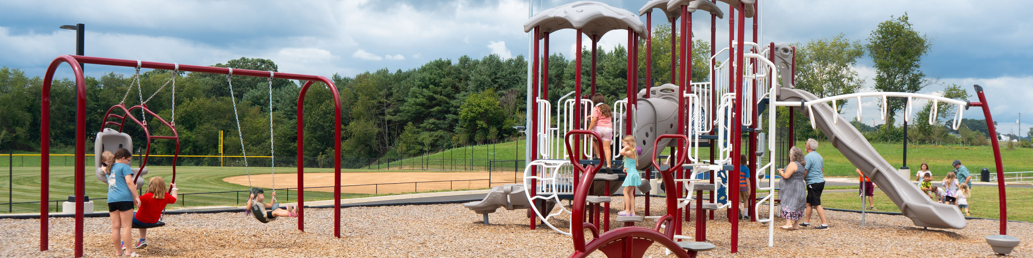 Children and adults enjoy a playground at Teel Park.
