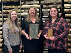 Pictured (L to R) are Tiffany Couch, Deputy Court Clerk Supervisor. Erica W. Conner, Clerk holding the Town of Christiansburg Minute Book 1854 - 1861. Jenna Bareford, Record Room Deputy Clerk holding the Christiansburg District Tax Book 1914.