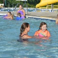A young swimmer works on water skills with her swim instructor at the Frog Pond Pool.