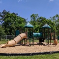 The playground at Plum Creek Park consists of slides and climbing areas on a mulch base.